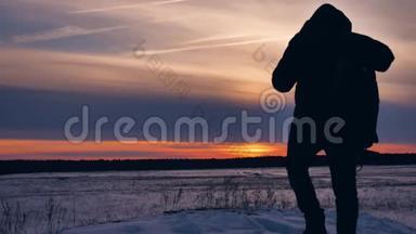 人们冬日剪影照喜雪阳.. 一群游客走在夕阳的剪影山上